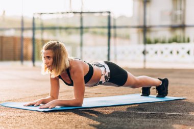 Tahtadaki kız dirseklere yaslanmış poz, paspas, zemin, pratik yapma, şekillendirme işi yapıyor