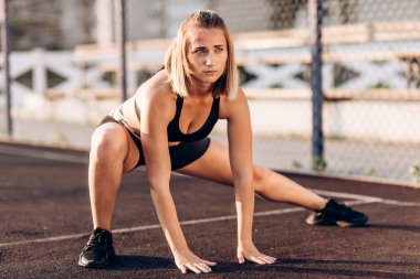 Egzersiz genç kız germe yapıyor. Sokak oyun alanında spor yapıyorum. Yaz, harika hava.