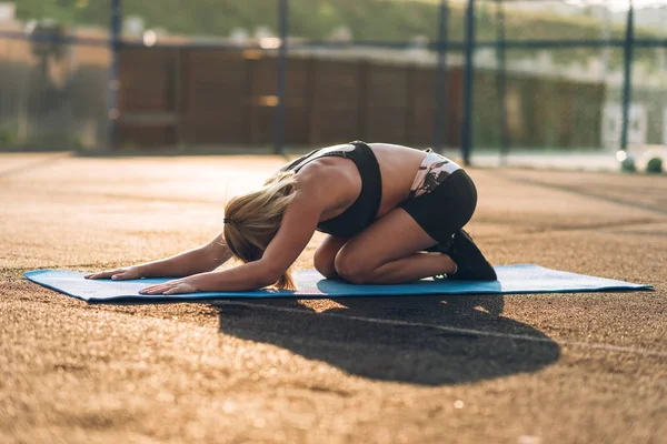 Çalışma dışarı, spor giyim, kapalı giyen pratik yoga, Seated ileri bend alıştırmada, paschimottanasana poz, oturan genç kadın