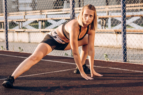 Спортивная девушка занимается спортом на площади
