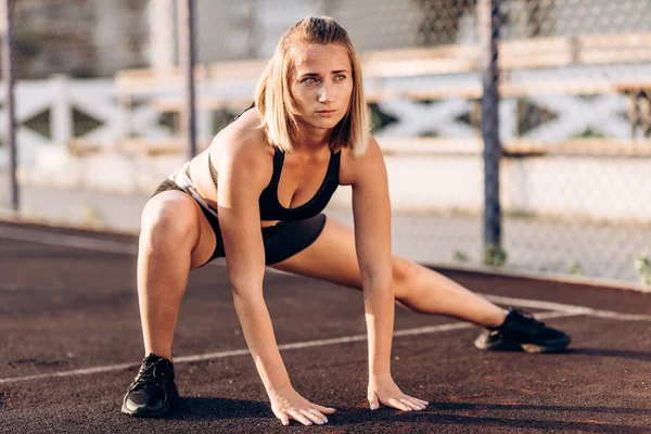 Egzersiz genç kız germe yapıyor. Sokak oyun alanında spor yapıyorum. Yaz, harika hava.