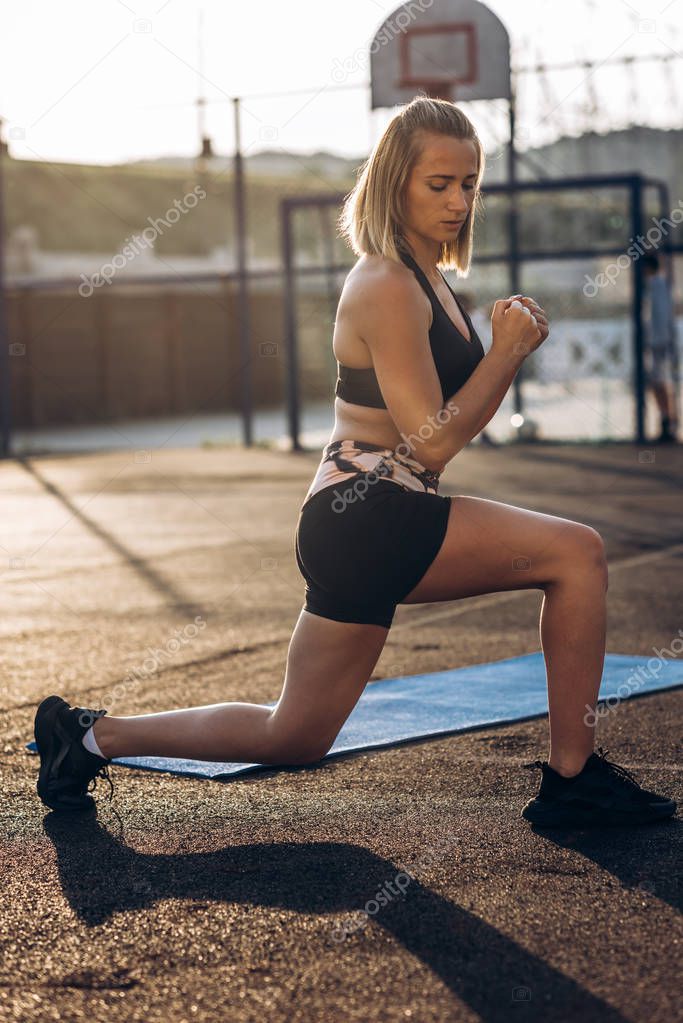 Pretty young woman doing fitness exercises outdoors on the playground with TRX . Healthy lifestyle, training on trx. Total Body Resistance Exercises. Summer time.