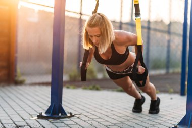 Egzersiz genç kız germe yapıyor. Sokak oyun alanında spor yapıyorum. Yaz, harika hava.