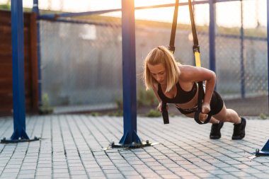 Egzersiz genç kız germe yapıyor. Sokak oyun alanında spor yapıyorum. Yaz, harika hava.