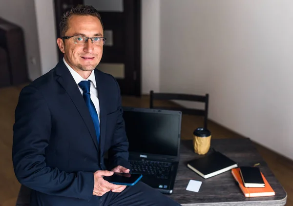 Genç işadamı ofiste dizüstü bilgisayarla çalışıyor..