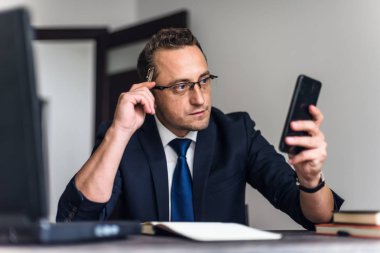 Genç işadamı ofiste dizüstü bilgisayarla çalışıyor..