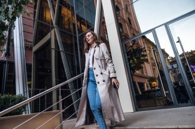Yetişkin Kafkasyalı Kendine Güvenen Genç İş Kadını Modern Ofis Binası 'nın dışında Akıllı Telefon Uygulaması Kullanıyor.