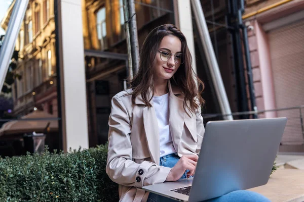 Ofisinin dışında dizüstü bilgisayarda çalışan güzel bir iş kadını. Serbest çalışma kavramı..