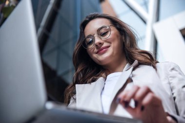 Elinde dizüstü bilgisayarı olan zarif genç bir kadının kopyalanmış görüntüsü.