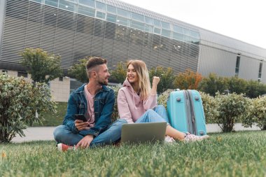 Çift dizüstü bilgisayar kullanıyor, havaalanı yakınlarında bekliyor. Seyahat. 