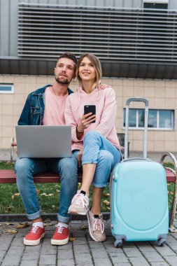 Seyahat ediyorum. Laptop kullanan çift havaalanı yakınlarında bekliyor.