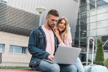 Seyahat ediyorum. Laptop kullanan çift havaalanı yakınlarında bekliyor..