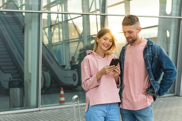 Seyahat. Bir çift telefon kullanarak taşıma yakınındaki bekliyor.
