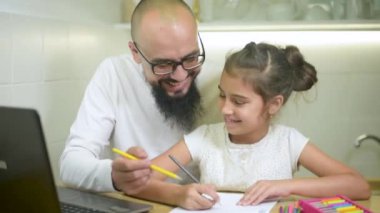 Baba ve kızı birlikte ev ödevi yapıyorlar..