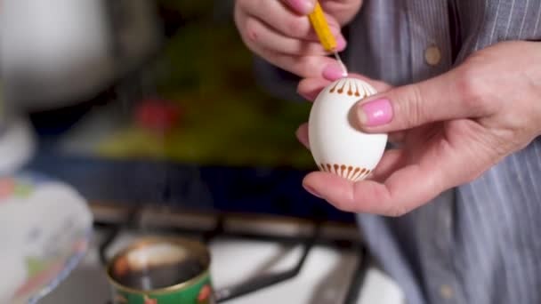 不同染料玻璃器皿背景下的传统蜂蜡彩绘工艺装饰复活节彩蛋的女艺术家 — 图库视频影像