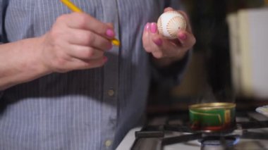 Kadınlar paskalya yumurtalarını mum ve boya ile otantik bir şekilde boyarlar. Evde Paskalya tatili.