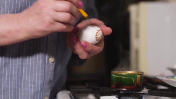 Mujer pintar huevos de Pascua de una manera auténtica con velas de cera y pintura. Casa Vacaciones de Pascua ocio. — Vídeos de Stock