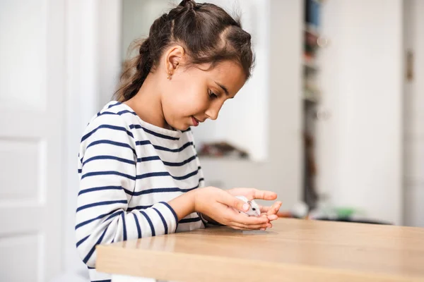 Çocuk, güzel beyaz cüce hamsterla oynuyor. Çocuk kucağında ve küçük bir evcil hayvan besliyor. Evin etrafında çocuklar ve evcil hayvanlar var. Küçük kız sevimli evcil hayvanla ilgileniyor. Sevdiklerinle samimi zaman geçir..