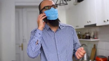 Sakallı, sağlık maskeli, cep telefonuyla konuşan beyaz bir genç. Akıllı telefon kullanan bir iş adamı..