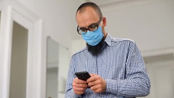 Obchodník Vousy Lékařské Masce Obchodník Používá Chytrý Telefon Muž Lékařské — Stock video