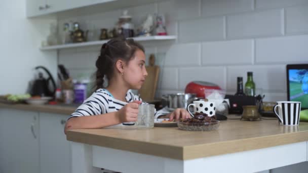 Cute Little Girl Descansando Una Silla Utiliza Ordenador Portátil Relojes — Vídeo de stock