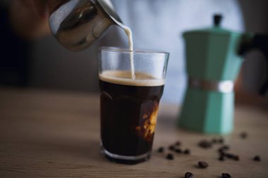 Espresso bir bardak süt dökme