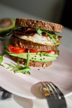 Yumurta ve pastırma bir plaka ile ekmek üzerine avokado