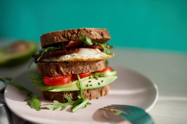 Yumurta ve pastırma bir plaka ile ekmek üzerine avokado