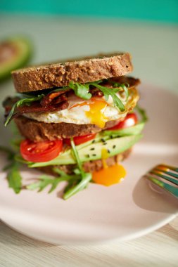 Yumurta ve pastırma bir plaka ile ekmek üzerine avokado