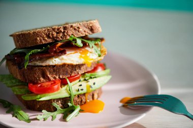 Yumurta ve pastırma bir plaka ile ekmek üzerine avokado