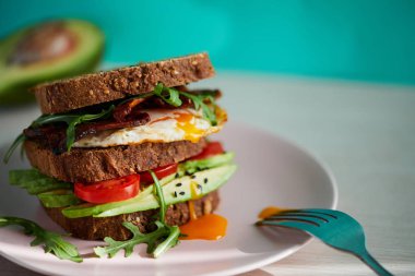 Yumurta ve pastırma bir plaka ile ekmek üzerine avokado