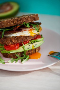Yumurta ve pastırma bir plaka ile ekmek üzerine avokado