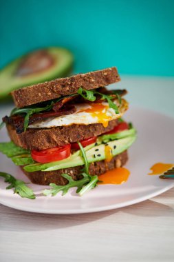 Yumurta ve pastırma bir plaka ile ekmek üzerine avokado