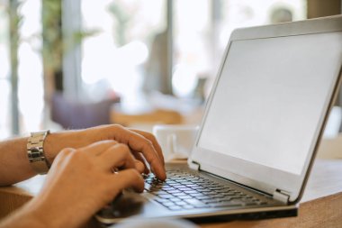 Kafede dizüstü bilgisayar kullanan adam