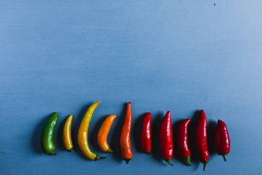 Kırmızı, yeşil ve sarı biber karışımı mavi bir arka plan üzerinde