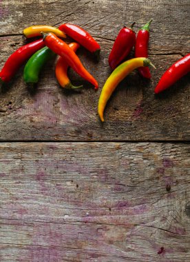 Kırmızı, yeşil ve sarı biber karışımı ahşap arka plan üzerinde