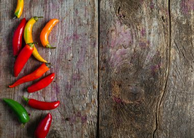 Kırmızı, yeşil ve sarı biber karışımı ahşap arka plan üzerinde