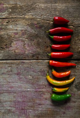 Kırmızı, yeşil ve sarı biber karışımı ahşap arka plan üzerinde