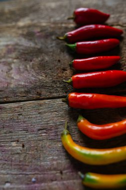 Kırmızı, yeşil ve sarı biber karışımı ahşap arka plan üzerinde