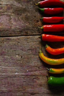 Kırmızı, yeşil ve sarı biber karışımı ahşap arka plan üzerinde