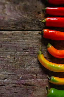 Kırmızı, yeşil ve sarı biber karışımı ahşap arka plan üzerinde