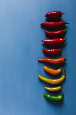 Kırmızı, yeşil ve sarı biber karışımı mavi bir arka plan üzerinde
