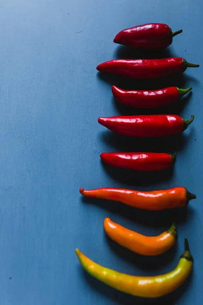 stock image Red, Green And Yelow Chili Peppers Mix On A Blue Background