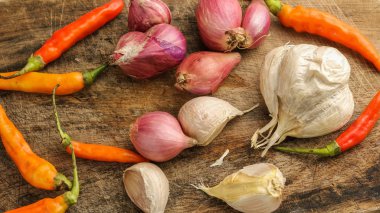 Çeşitli Endonezya baharat ve otlar. Kırmızı soğan, sarımsak, soğan ve rustik arka plan üzerinde sıcak biber.