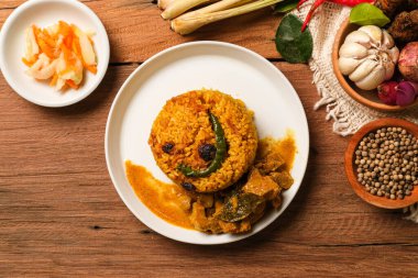 Hint Mutton Biryani Tabağı ahşap masada servis edildi. Hindistan 'dan tipik yemek, baharat ve basmati pilavı ile karıştırılmış keçi etinden yapılır.