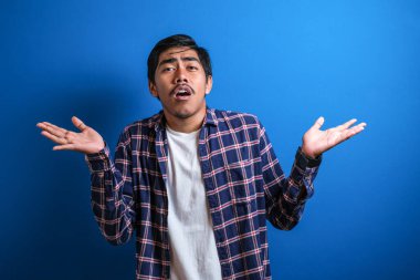 Mavi ekose gömlekli genç bir öğrenci kollarını silkiyor, ne bileyim, mavi arka plana karşı bir şey yapamıyor.