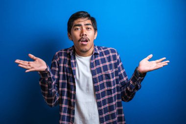 Mavi ekose gömlekli genç bir öğrenci kollarını silkiyor, ne bileyim, mavi arka plana karşı bir şey yapamıyor.