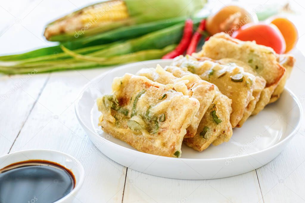 Tempe Mendoan is a traditional food made from tempeh covered in flour batter with a mixture of sliced leeks and spices. cooked by frying