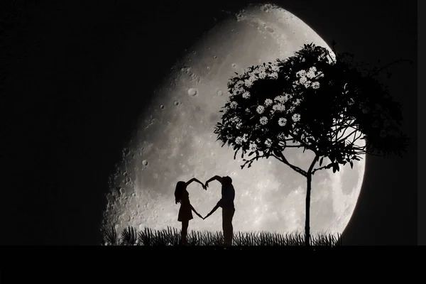 Deux lunes amoureuses la nuit, une grosse lune, un homme et une femme font une figure du cœur — Photo