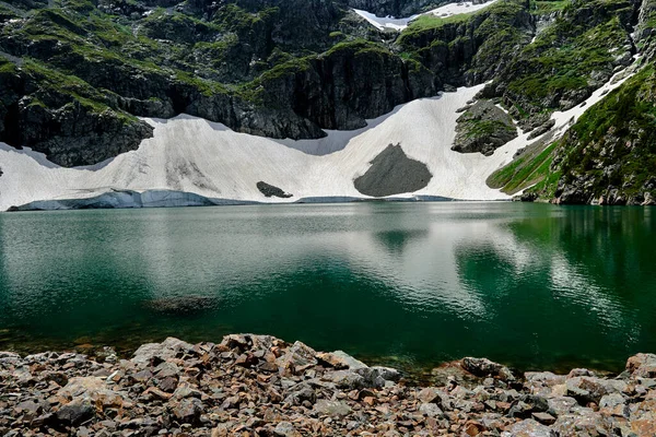 Lac de haute montagne avec eau turquoise en gros plan sur fond de montagnes. Grand glacier dans les montagnes alimentant le lac des hautes terres — Photo